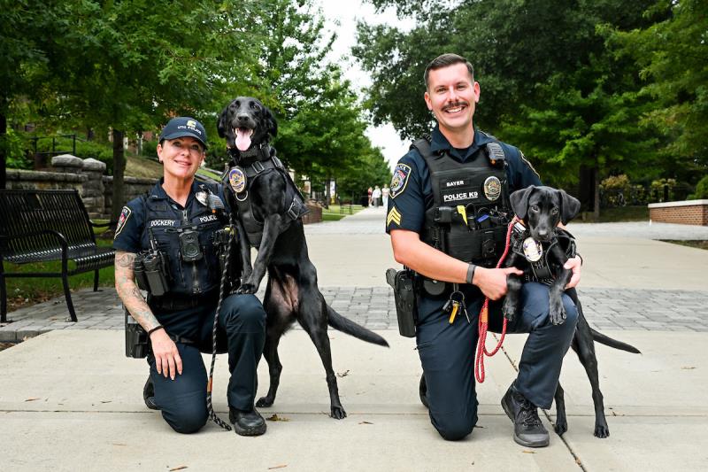 Cpl. Ginger Dockery with Sophie (left) and Sgt. Aaron Bayer with Lucky