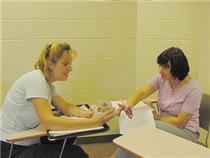 Leslie Melton, a TESOL student, helps local resident with the use of flash cards.