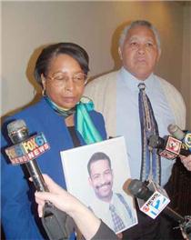 Dr. Loretta Prater and Rev. David Prater with picture of their son. Click to enlarge.