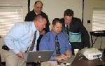 WCS SchoolCast:  (Back) Bob Phillips, Territory Manager, and Timothy McCarrell, President/CEO, of High Ground Solutions, distributor for the SchoolCast Rapid Alert and Notification System, assists Mike Culberson, principal of LaFayette Middle School, and Michael Tipton, Walker County Schools Coordinator of School Improvement, in setting up school accounts.