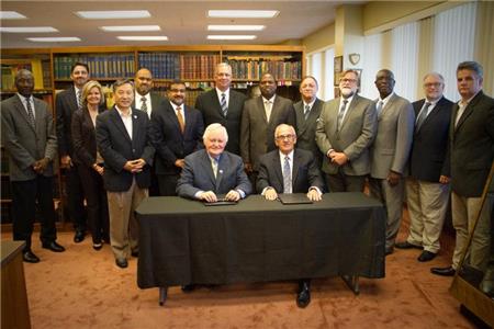 Bishop Sam N. Clements (front right), general overseer of the Church of God of Prophecy, and Dr. R. Lamar Vest (front left), president of Pentecostal Theological Seminary, sign a memorandum of understanding between the organizations. Others in attendance included (from left) Bishop David Bryan, executive director of Leadership Development; Bishop Brian Sutton, partnership coordinator and program coordinator; Kathryn Creasy, international director of Children's Ministries; Dr. David Han, vice president of academics for Pentecostal Theological Seminary; Bishop Gabriel Vidal, general presbyter of South America; Bishop Ben Feliz, general presbyter of Mexico, Central America, and Spanish-speaking Caribbean; Bishop Tim Coalter, general presbyter of North America; Stephen Masilela, general presbyter of Africa; Bishop David Browder, general presbyter of Asia, Oceania, and Pacific Islands; Bishop Clayton Endecott, general presbyter of Europe, the CIS, and the Middle East; Bishop Clayton Martin, general presbyter for the Caribbean; Mark Menke, instructor for the Center for Biblical Leadership; and Kirk Rising, international director of Youth Ministries. 
