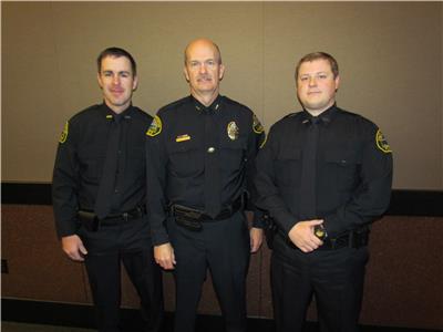 New officers Stephen Pendergrass (left) and Larry Johnson (right) pose with Chief Jason Parker during Tuesday morning’s meeting of the Dalton Public Safety Commission