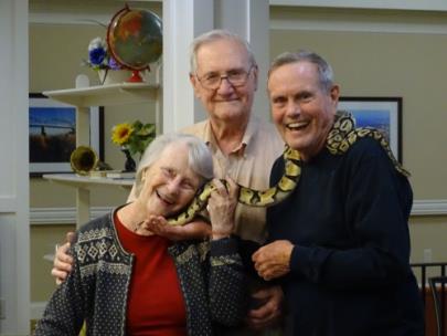 Morning Pointe of Chattanooga – Shallowford residents Nancy Kimbro and Tom Donovan cuddle up to Kaa, the Chattanooga Zoo's balboa python, while resident Clyde Edwards looks on. Ms. Donovan and Mr. Edwards are longtime supporters of the zoo and have a history of volunteering there.