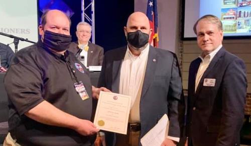Jeff Ownby (left) receives his Professional Manager certification from Tim Reeve (center) as Commission Chairman Jevin Jensen looks on