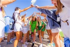 Seniors create a tunnel for the freshmen to walk through on their way to the Upper School