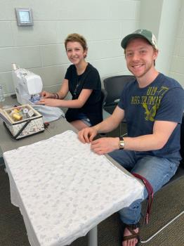 Lee senior Nathan Melton, right, making scarves with Michaela Mackie’s sister, Kaydn, a local high school student and cancer survivor