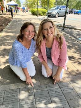 Former Cleveland State employee, Kim Hicks (left), admires her recently installed brick on the Cleveland State campus with Stacey Swafford, CSCC events coordinator