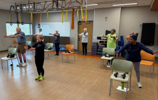 Certified instructor Jane Woolley (center) leads a warm-up during a community fitness class earlier this month