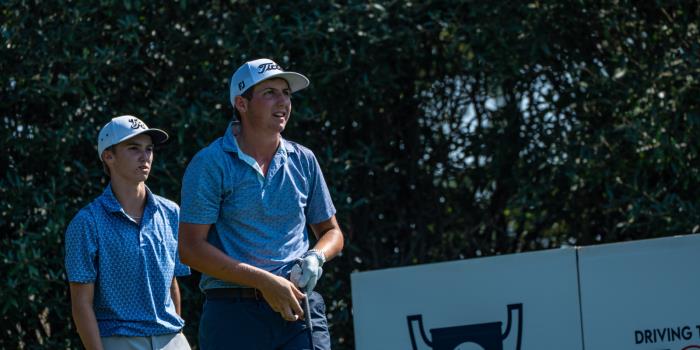 Carson Andreoni follows the flight of his opening tee shot while teammate Casen Justice looks on