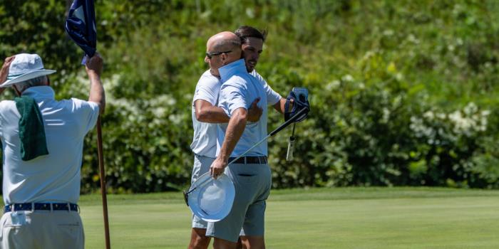Tucker Jenkins and Ryan Greer hug after Greer's winning birdie putt on the first playoff hole