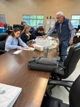 Members of the independent CPA firm compare vote total tabulations