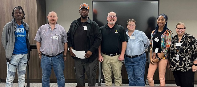 Graduates of a former forklift operator course pose for a photo during their graduation ceremony at the Goodwill Opportunity Campus